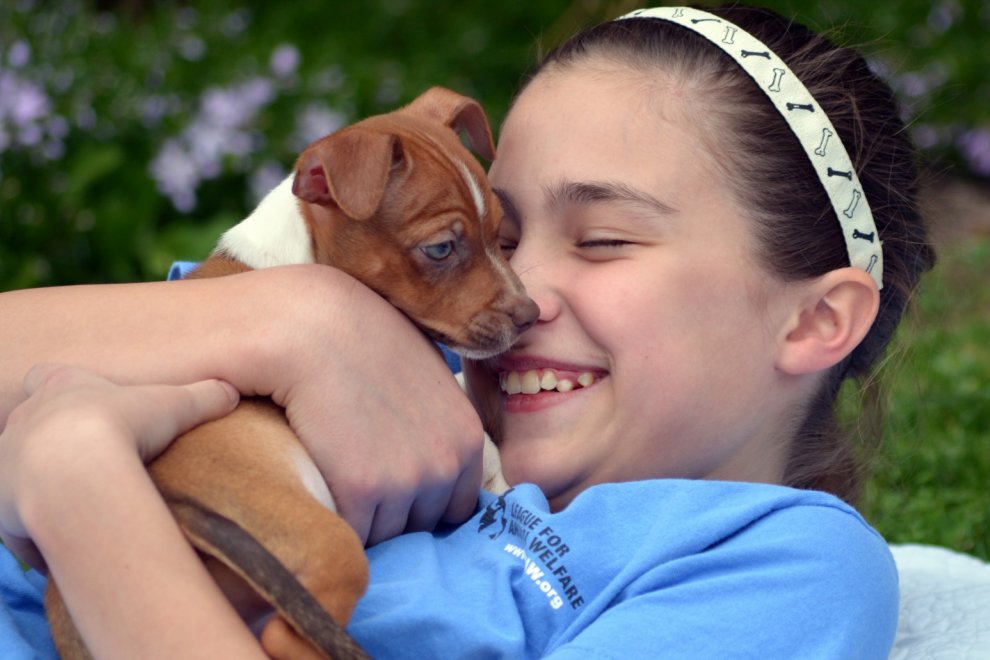 a girl hugging a dog